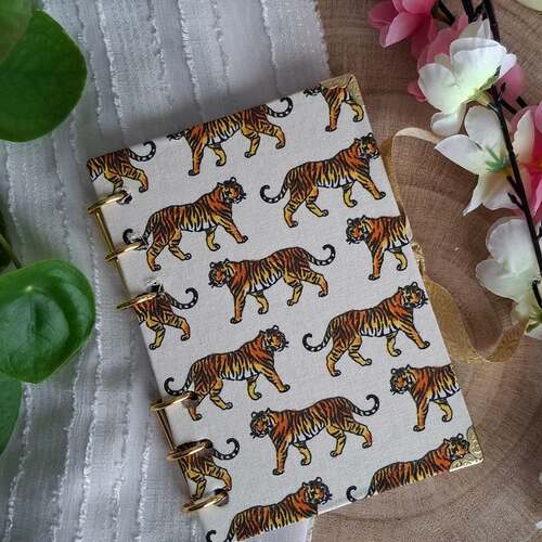 instagram-7 🐅Mini Carnet RAJAH au format A6.
Reliure à spirales avec anneaux doré et couverture en tissu.