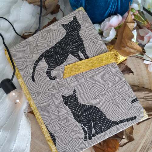 instagram-6 🐈‍⬛🧙Le grimoire franchira les portes du royaume dans une semaine.
Avez-vous réservé le vôtre ? 

👉Cahier A5 couverture tissu chat noir et Jacquard or
Pages imprimées avec illustrations de chats aux crayons. 
Chaque pages est teintées avec du thé aux épices.
Légèrement parfumé.
Disponible le 12 Mai 🌟